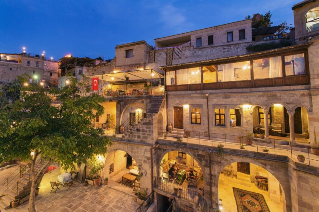 Century Cave Hotel stone courtyard illuminated at dusk in Göreme, Cappadocia